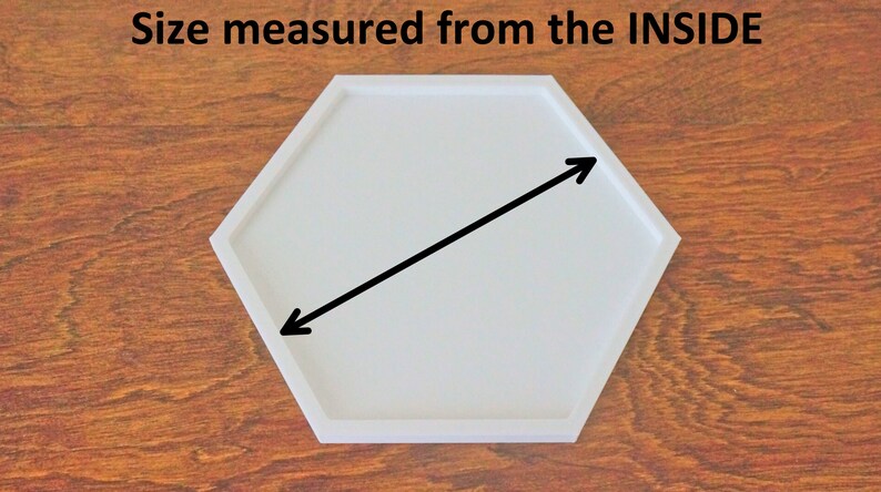 Puede incluir: Bandeja hexagonal blanca con una flecha negra apuntando diagonalmente hacia el interior. El texto "Size measured from the INSIDE" est&aacute; por encima de la bandeja.