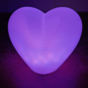 May include: A heart-shaped, purple LED light illuminates the room with a soft glow.
