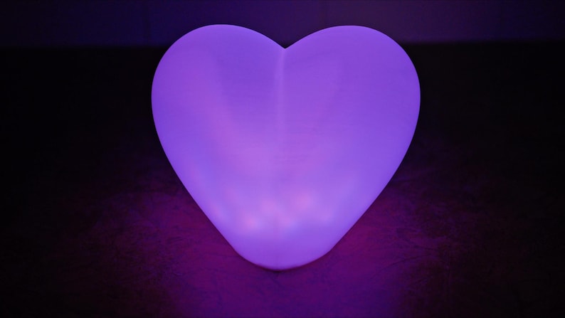 May include: A heart-shaped, purple LED light illuminates the room with a soft glow.