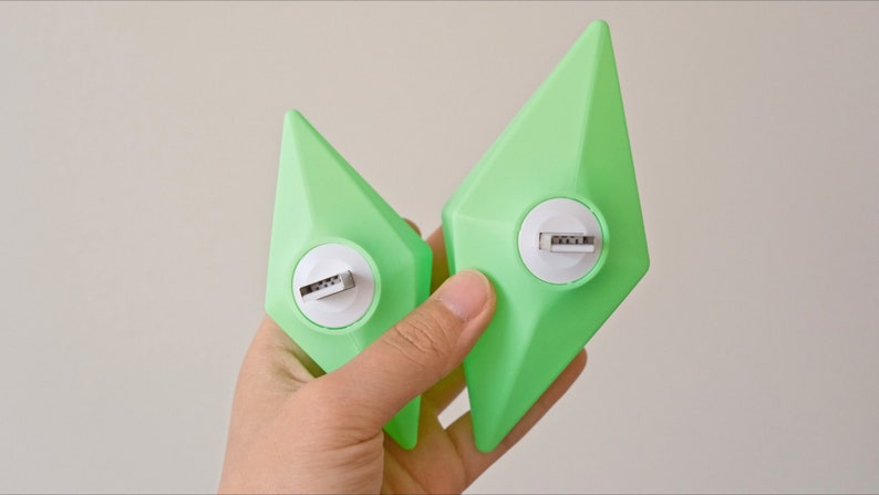 May include: Two green diamond-shaped USB flash drives with white accents and a silver USB connector.