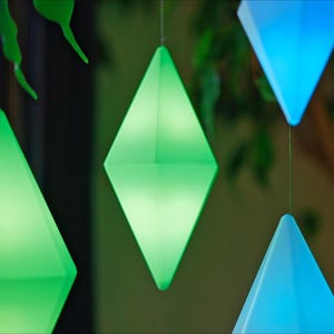 May include: Five diamond-shaped hanging lights, two green and three blue, are suspended from the ceiling. The lights are illuminated, casting a soft glow.