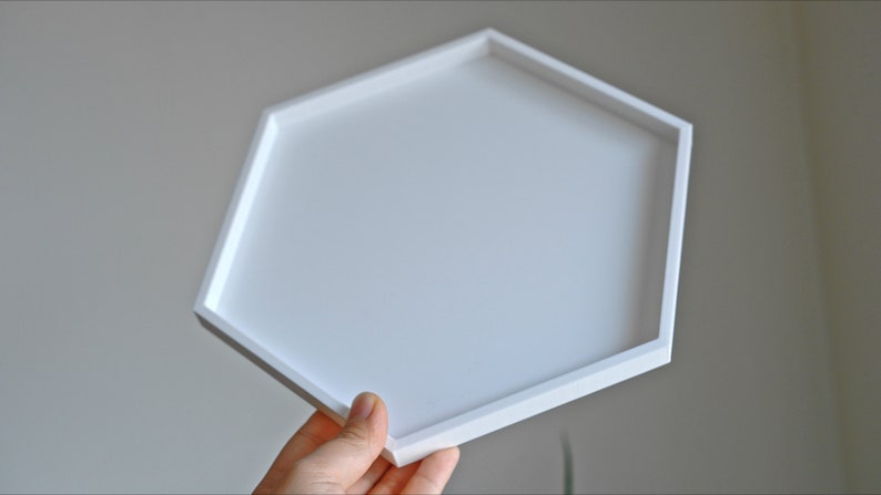 May include: A white hexagonal tray with a smooth surface. The tray is made of a sturdy material and has a modern design.