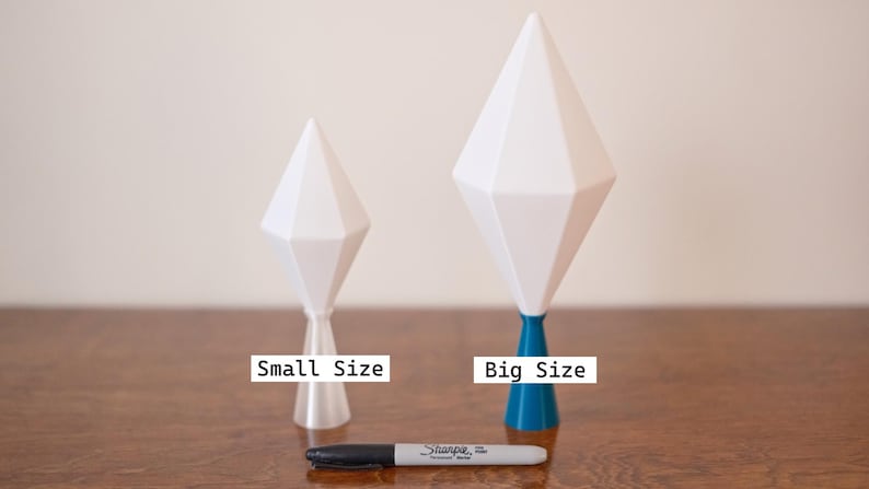 May include: Two white geometric sculptures, one small and one large, with a Sharpie marker for size comparison. The larger sculpture has a blue base and a brown accent. The smaller sculpture has a clear base. Text on the image reads "Small Size" and "Big Size".