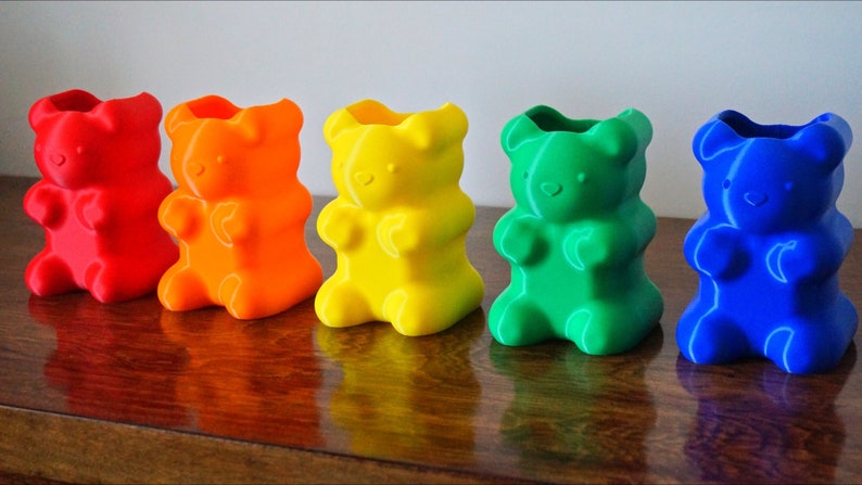 Puede incluir: Cinco portal&aacute;pices con forma de osito de goma en un arco&iacute;ris de colores: rojo, naranja, amarillo, verde y azul. Los portal&aacute;pices son de pl&aacute;stico y tienen un acabado liso y brillante.