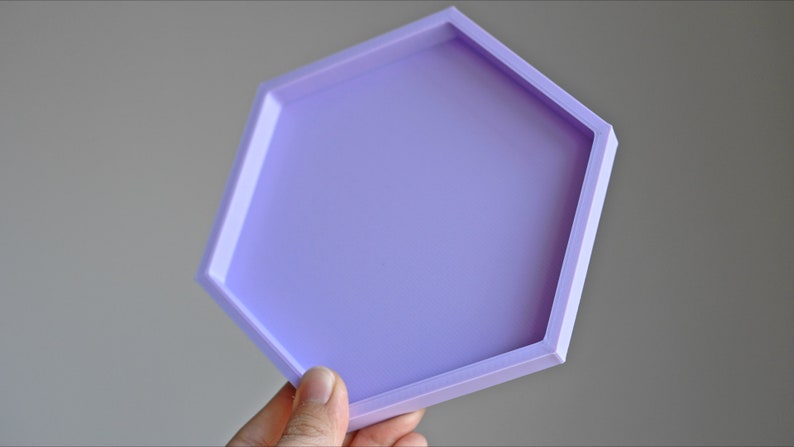 May include: A light purple hexagonal tray with a smooth surface. The tray is made of a durable material and is perfect for displaying small items.