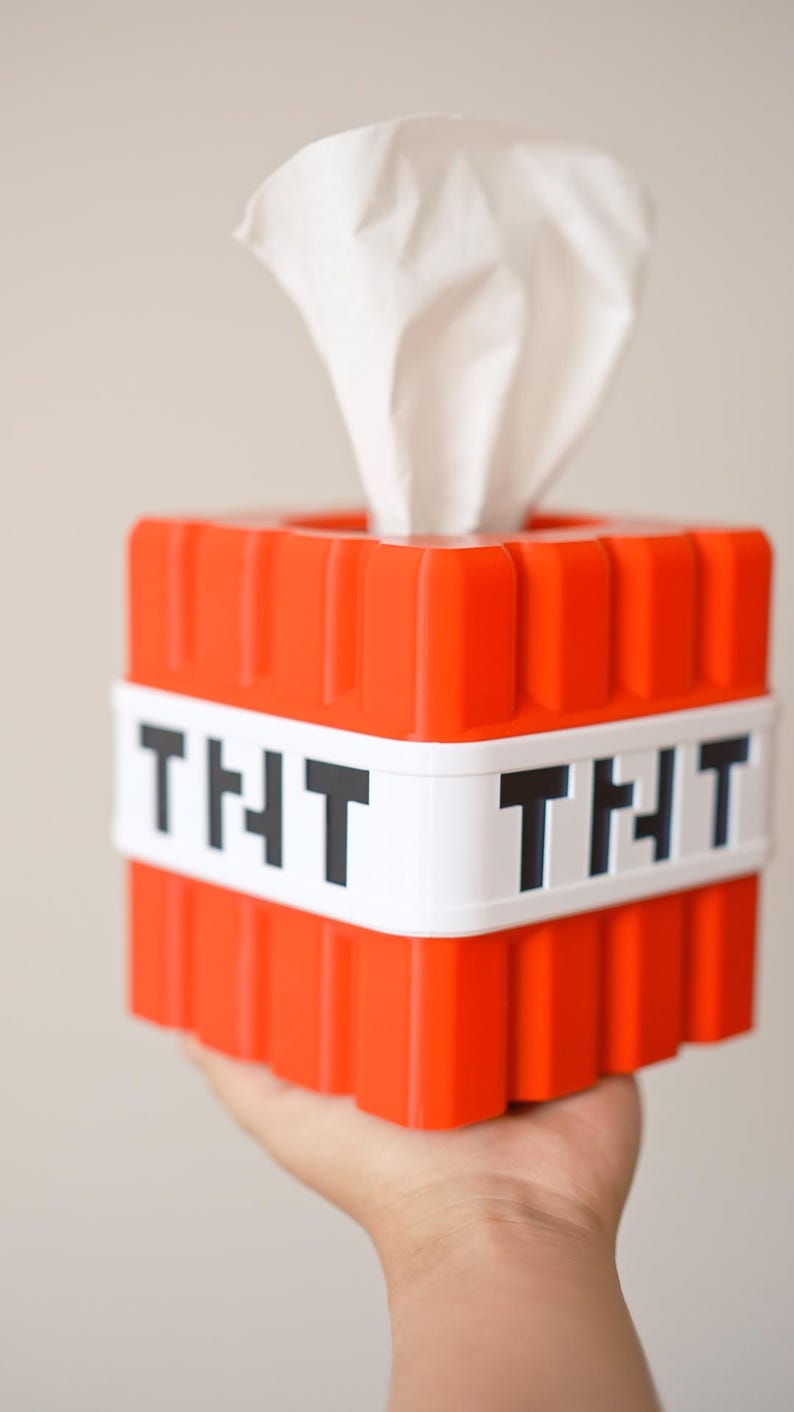 K&ouml;nnte beinhalten: Eine rote und wei&szlig;e Tissuebox in Form eines Minecraft TNT-Blocks. Die Box hat das Wort "TNT" in Schwarz aufgedruckt.