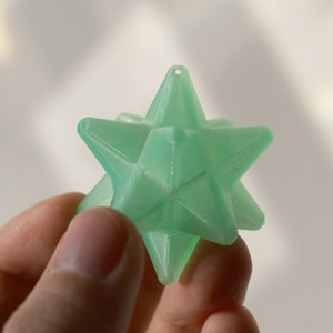 May include: A light green, 3D printed, star-shaped ornament with a hole at the top for hanging.