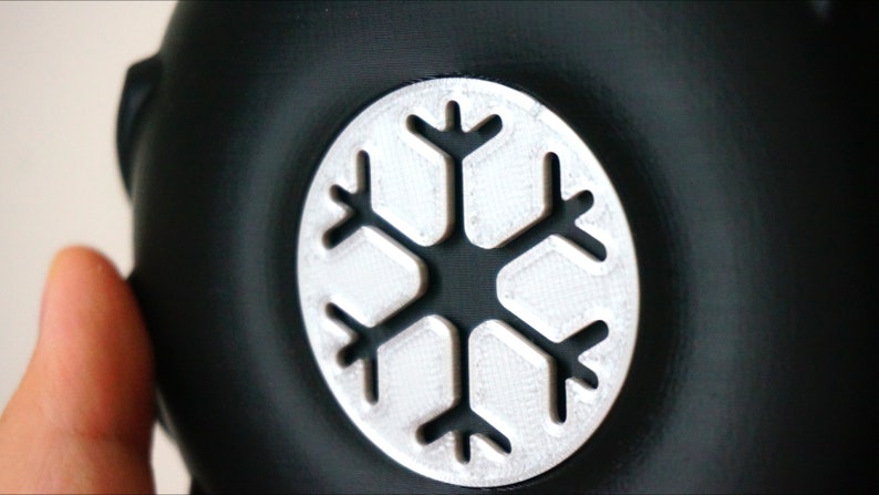 May include: A black round object with a silver snowflake design.