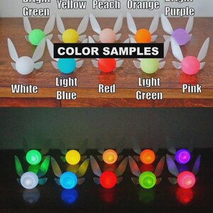 May include: A collection of colorful fairy-like ornaments with glowing orbs. The ornaments are in various colors, including white, green, yellow, peach, orange, purple, light blue, red, and pink. The text "COLOR SAMPLES" is displayed.