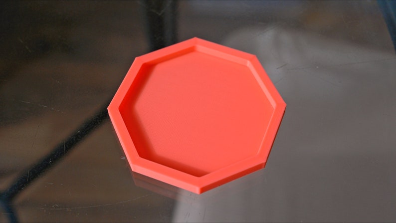 May include: A bright orange hexagonal silicone mold for crafting. The mold has a raised edge around the perimeter.