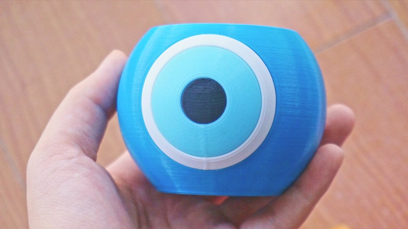 May include: A blue glass paperweight with a white and blue evil eye design.