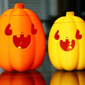 May include: Two Halloween jack-o'-lantern decorations, one orange and one yellow, with carved faces and lit from inside.