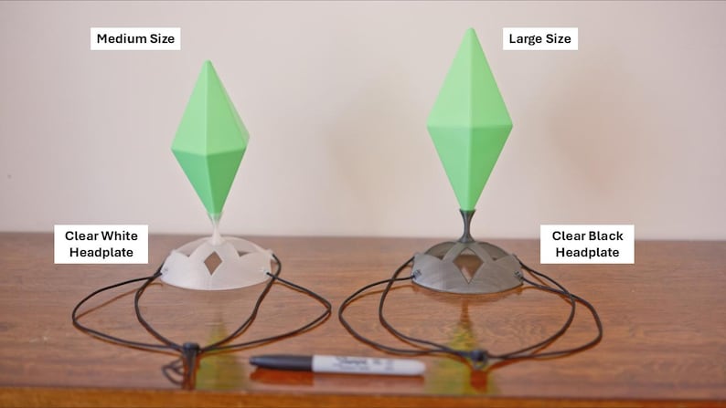 May include: Two decorative headpieces with green diamond-shaped tops and clear bases. One is white, the other black. The text on the image reads "Medium Size", "Large Size", "Clear White Headplate", and "Clear Black Headplate". A black marker is in the foreground.