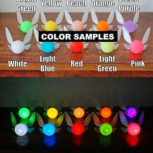 May include: A selection of fairy-shaped LED lights in colours such as white, green, yellow, orange, and purple. The text "COLOR SAMPLES" is displayed above the lights. The lights are arranged in two rows, with the bottom row illuminated.