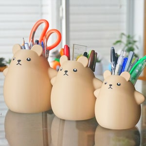 May include: Three brown bear-shaped desk organizers with a variety of pens, pencils, and scissors inside.