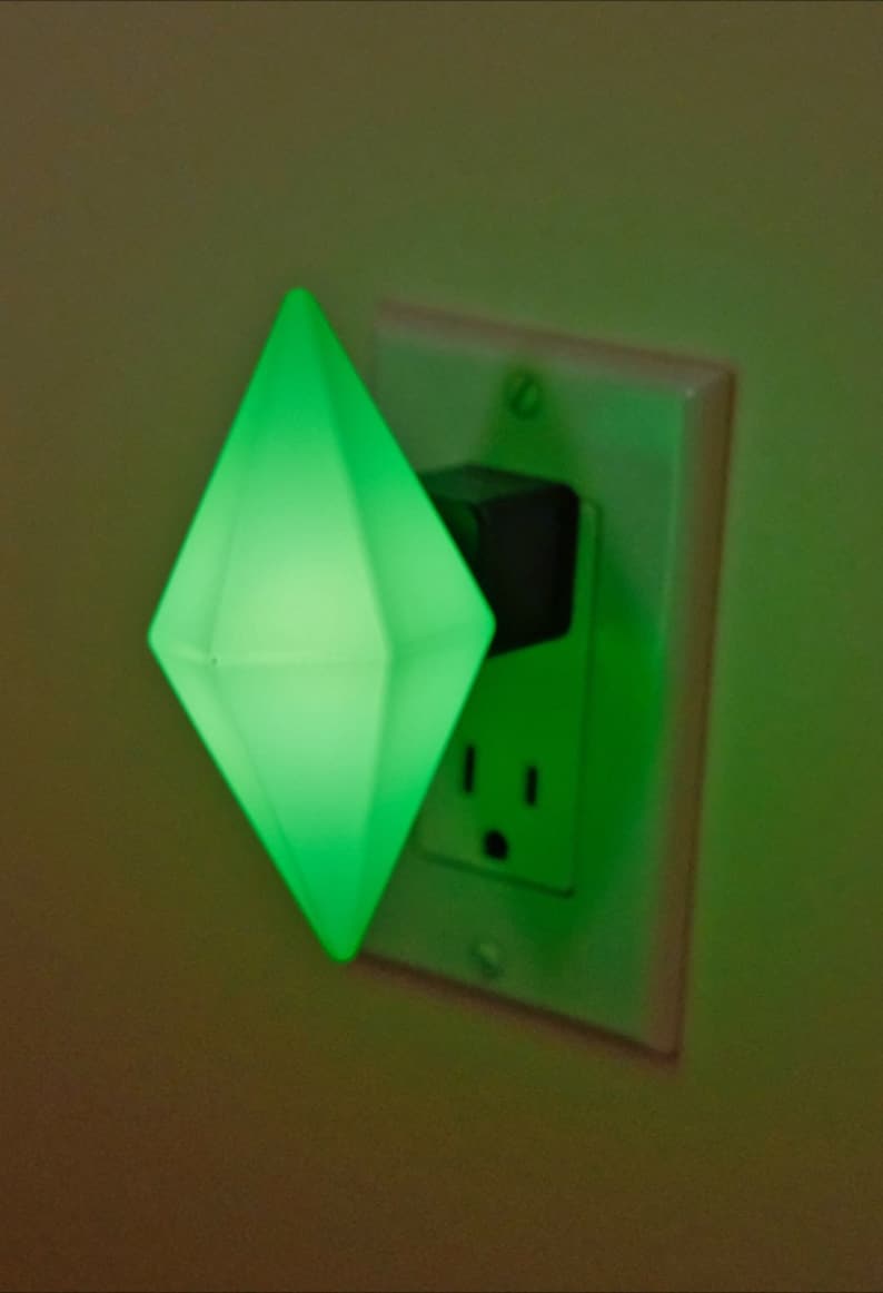 May include: A green diamond-shaped night light plugged into a standard electrical outlet.