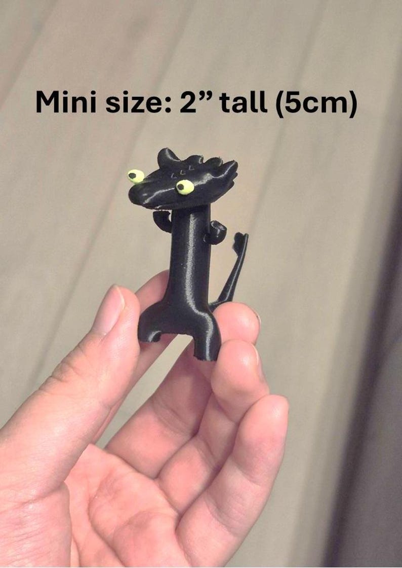 May include: A black figurine of a dragon-like creature, 2 inches tall, with large yellow eyes. The figure has a long neck, small arms, and a tail. The text "Mini size: 2" tall (5cm)" is above the figure.