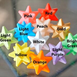 May include: Ten star-shaped objects in various colors, including pink, red, peach, light green, light blue, white, gold, bright green, yellow, light purple, and orange.