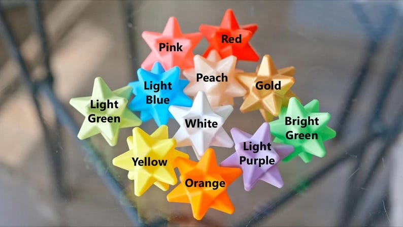 May include: Ten star-shaped objects in various colors, including pink, red, peach, light green, light blue, white, gold, bright green, yellow, light purple, and orange.