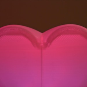 May include: A pink heart-shaped lamp with a textured surface.