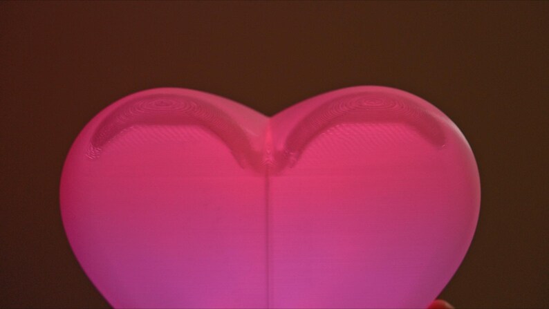May include: A pink heart-shaped lamp with a textured surface.