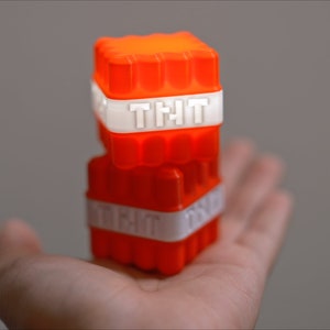Op de afbeelding: Twee gestapelde oranje plastic blokken met het woord "TNT" in wit erop gedrukt.