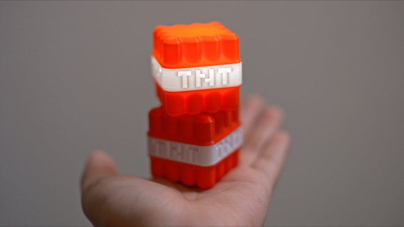 Op de afbeelding: Twee gestapelde oranje plastic blokken met het woord "TNT" in wit erop gedrukt.