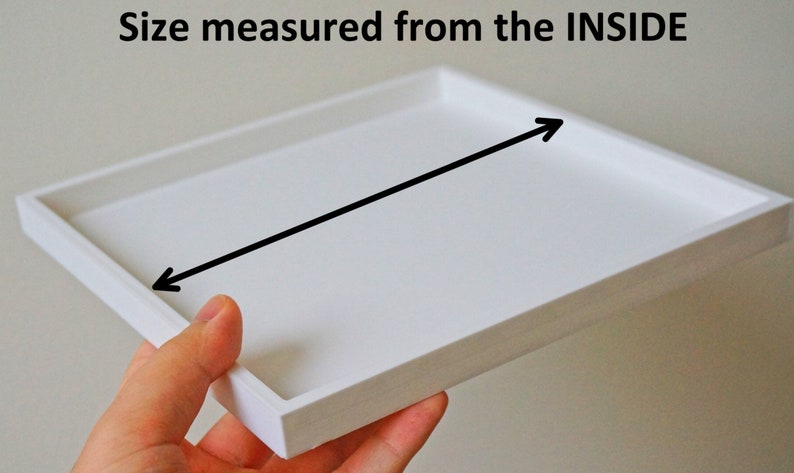 May include: White square tray with a black arrow pointing to the inside of the tray. The text "Size measured from the INSIDE" is above the tray.