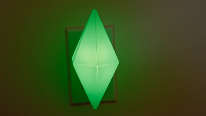 May include: A green diamond-shaped night light plugged into an electrical outlet.