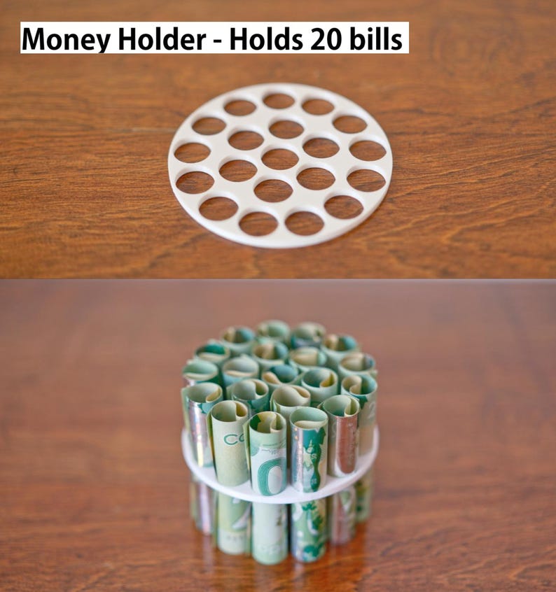 Puede incluir: Un portamonedas blanco con m&uacute;ltiples aberturas circulares, que contiene billetes enrollados. El texto "Money Holder - Holds 20 bills" est&aacute; en la parte superior. El soporte est&aacute; sobre una superficie de madera.