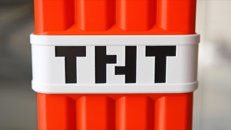 K&ouml;nnte beinhalten: Nahaufnahme eines roten und wei&szlig;en Plastikblocks mit dem Wort "TIT" in schwarzen Buchstaben.