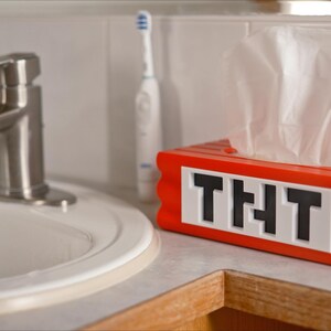 May include: Red and white tissue box shaped like a Minecraft block with the text "THT" on the front.