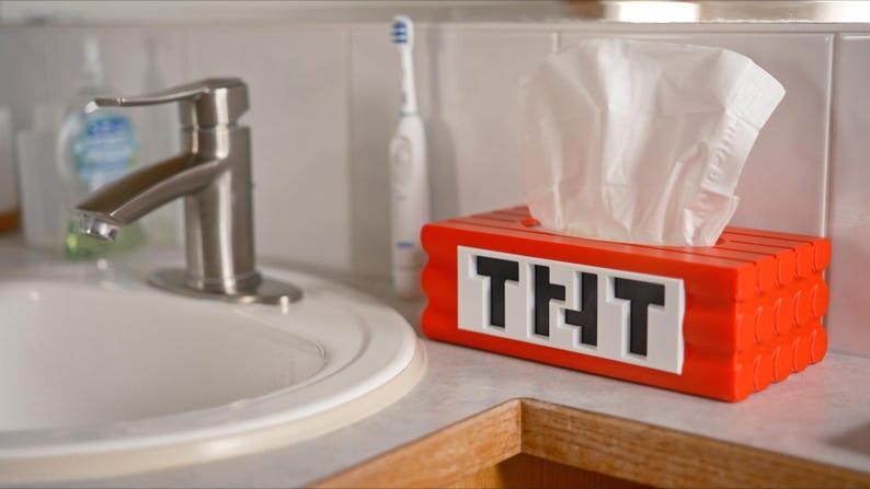 May include: Red and white tissue box shaped like a Minecraft block with the text "THT" on the front.