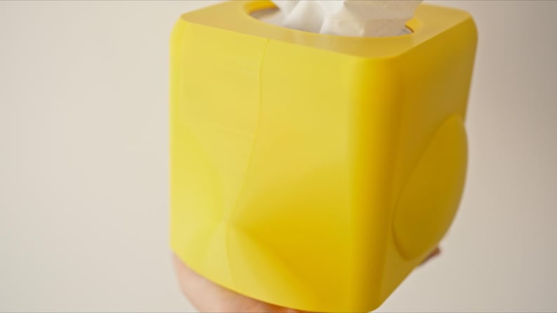 Pu&ograve; includere: Un porta fazzoletti quadrato di colore giallo brillante. La scatola &egrave; realizzata in plastica e ha una finitura liscia e lucida.