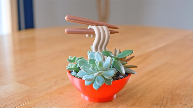 May include: A set of three ceramic mugs with a speckled, matte finish. The mugs are in shades of cream, light gray, and dark gray. Each mug has a simple, minimalist design, perfect for coffee or tea.
