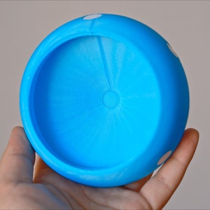 K&ouml;nnte beinhalten: Eine blaue Plastiksch&uuml;ssel mit wei&szlig;en Punkten. Die Sch&uuml;ssel ist leer und hat eine glatte, abgerundete Oberfl&auml;che.
