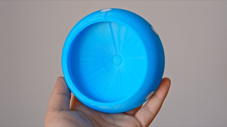 K&ouml;nnte beinhalten: Eine blaue Plastiksch&uuml;ssel mit wei&szlig;en Punkten. Die Sch&uuml;ssel ist leer und hat eine glatte, abgerundete Oberfl&auml;che.