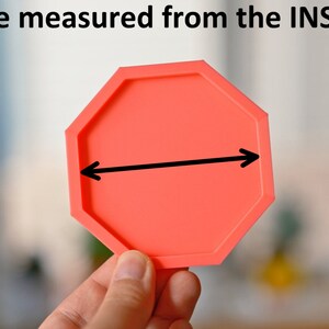 May include: A bright red octagonal silicone mold with a black arrow pointing to the inside diameter.  Size measured from the INSIDE.