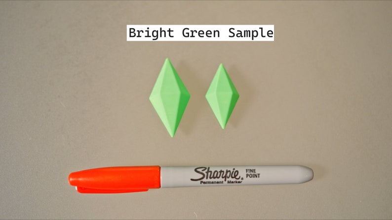 May include: Two bright green diamond-shaped plastic objects, one larger than the other, on a light gray surface. A red and white Sharpie fine point permanent marker is also on the surface. The text "Bright Green Sample" is at the top of the image.