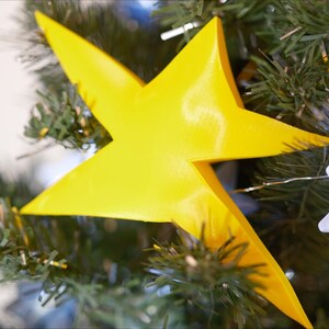 May include: A bright yellow star-shaped Christmas tree topper.