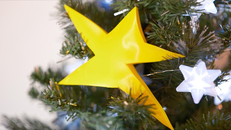 May include: A bright yellow star-shaped Christmas tree topper.