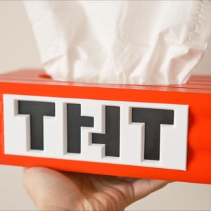 May include: Red tissue box holder shaped like a Minecraft block with the word "TNT" printed on the front.