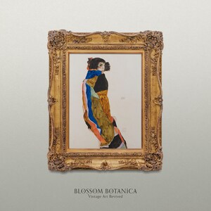 May include: A framed painting of a woman in a colorful, abstract dress. The painting is in a gold frame with ornate details. The title "BLOSSOM BOTANICA Vintage Art Revived" is printed below the frame.