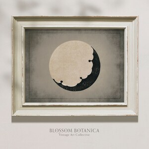 Puede incluir: Una impresi&oacute;n enmarcada con una est&eacute;tica vintage que presenta un dise&ntilde;o de luna creciente en blanco y negro sobre un fondo beige. La impresi&oacute;n se titula "BLOSSOM BOTANICA Vintage Art Collective".