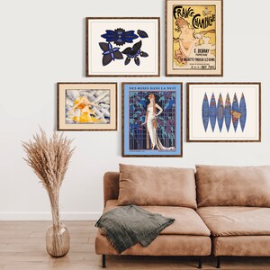 Puede incluir: Una colecci&oacute;n de impresiones art&iacute;sticas enmarcadas exhibidas en una pared blanca sobre un sof&aacute; marr&oacute;n. Las impresiones presentan anuncios vintage y dise&ntilde;os abstractos en varios colores, incluyendo azul, amarillo y beige. Un jarr&oacute;n de hierba de la pampa seca est&aacute; en el suelo.