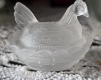 Salero antiguo de cristal esmerilado con forma de gallina en un nido.