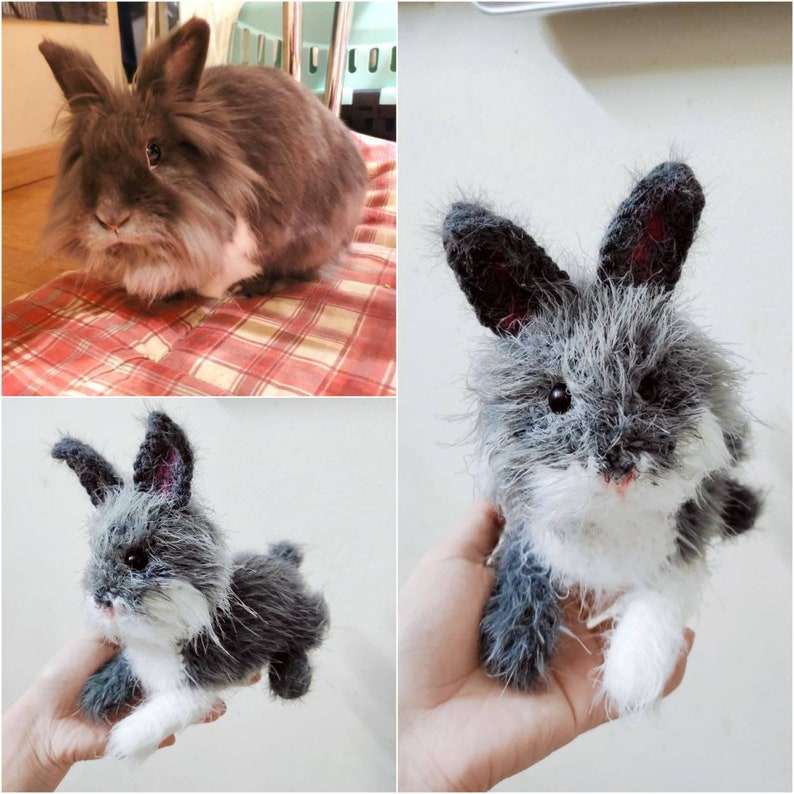 May include: A gray and white fluffy rabbit plush toy. The toy has a long, soft fur and a white face with black eyes and a pink nose. The toy is sitting on a hand.