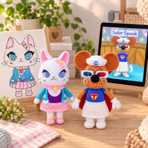 May include: Two handmade crochet dolls standing side by side. The left doll is a white cat with blue eyes, a pink bow, a blue cardigan, and a pink skirt. The right doll is a brown mouse wearing a white sailor hat, 3D glasses, and a blue cape.