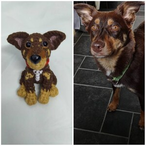 Puede incluir: Un juguete de perro de crochet marr&oacute;n y beige, sentado sobre una superficie blanca. El juguete es una representaci&oacute;n realista de un perro, con pelo marr&oacute;n, patas beige y una nariz negra.