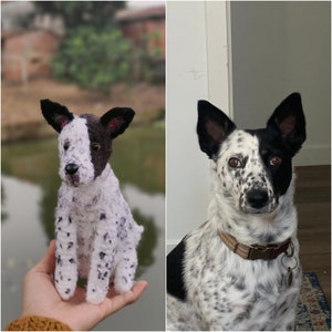 May include: A handmade crochet dog figurine featuring a white coat with black spots and a solid black patch over one ear and eye, modeled after a real dog with similar black and white spotted fur, pointed ears, and a brown collar with a metal tag.
